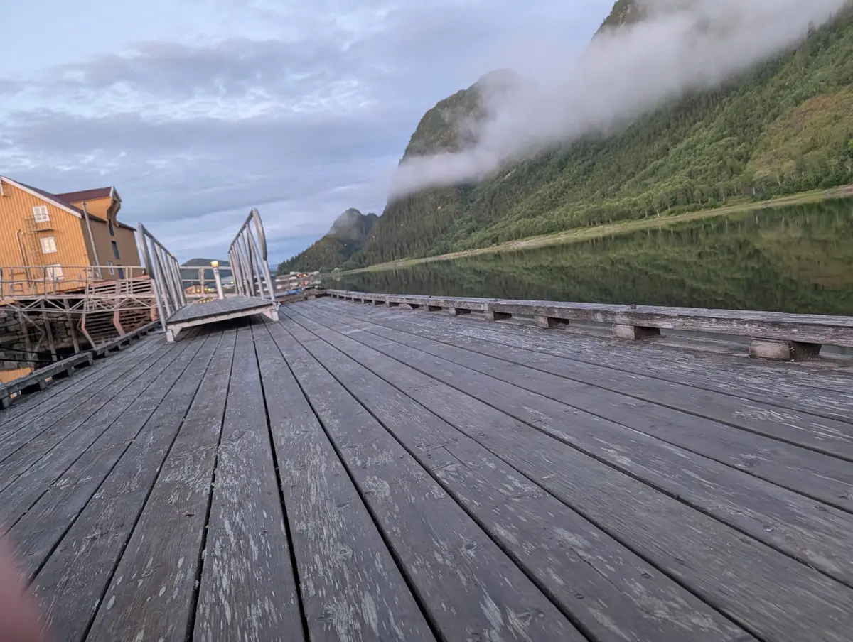 Utsikt fra brygge mot fjell og fjord
